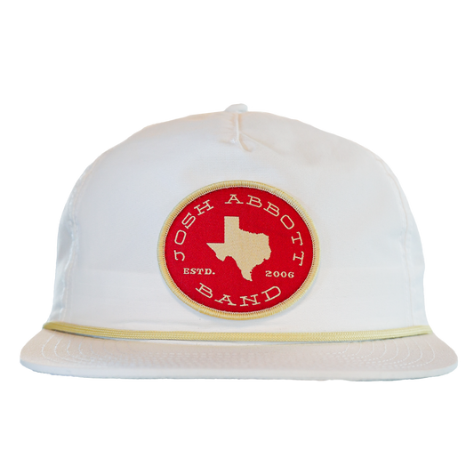 White baseball-style cap with a red circular patch featuring the outline of Texas.